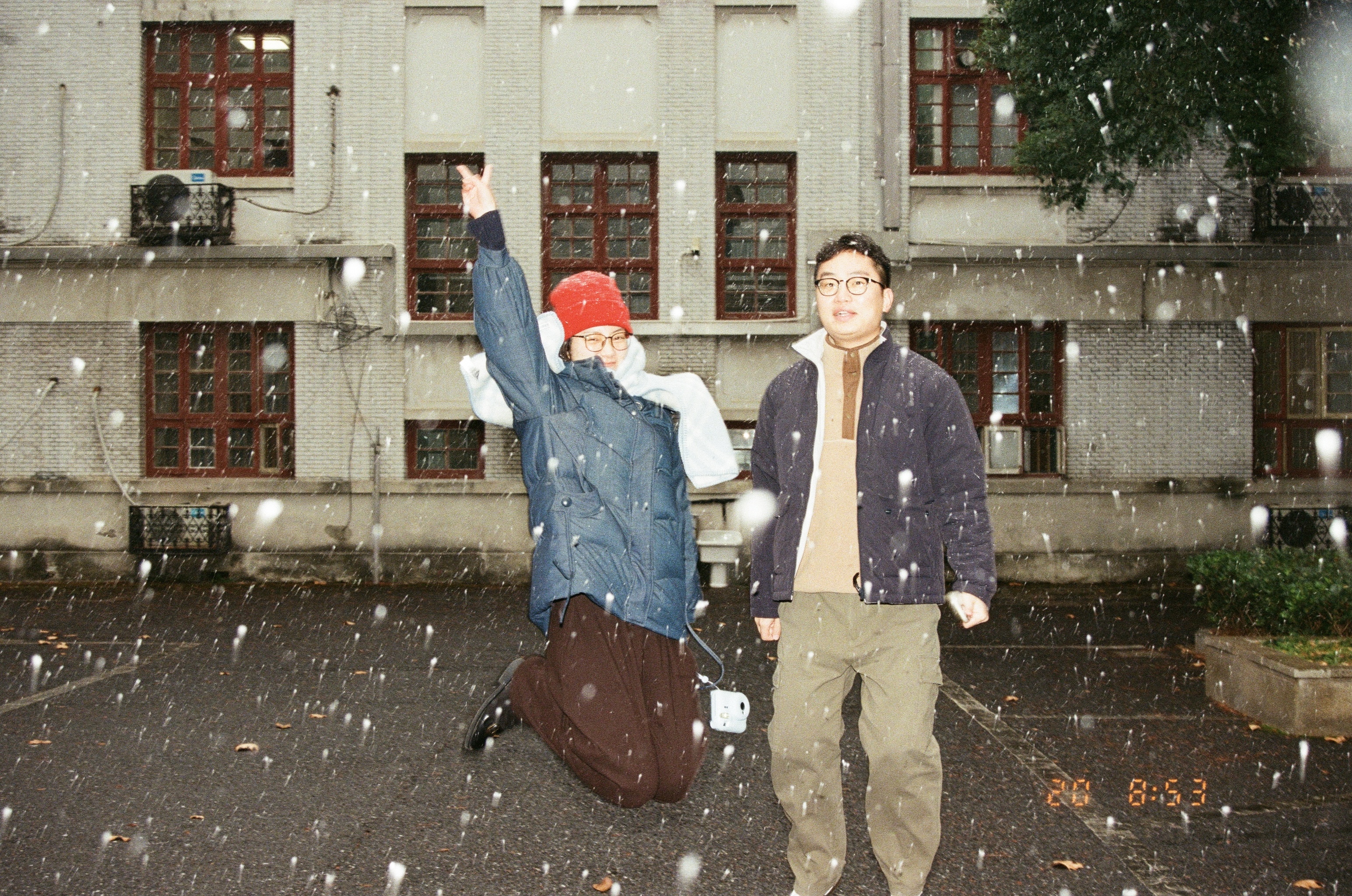 漫天飞雪中，我们在老办公楼前留下最后的合影，红帽子在雪中格外显眼。